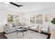 Open-concept living room with comfortable sectional seating, a ceiling fan, and lots of natural light at 11110 105Th Ave, Largo, FL 33778