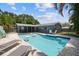 Backyard pool with patio and lounge chairs, surrounded by lush tropical landscaping and privacy fence at 11110 105Th Ave, Largo, FL 33778