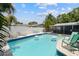 Backyard pool with patio and lounge chairs, surrounded by lush tropical landscaping and privacy fence at 11110 105Th Ave, Largo, FL 33778