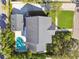 Aerial shot of home showcasing the roof, driveway, lawn, and backyard pool with mature landscaping and a classic neighborhood street at 1114 Culbreath Isles Dr, Tampa, FL 33629
