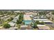 Aerial view of a light blue multi-unit building with palm trees, mature trees, carports, and a community pool at 11447 Park Blvd # 205, Seminole, FL 33772