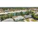 Aerial view of a light blue multi-unit building in a residential area with palm trees and a green lawn at 11447 Park Blvd # 205, Seminole, FL 33772