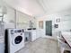 Bright community laundry room with multiple machines, utility sink, tiled floors, and laundry instructions posted at 11447 Park Blvd # 205, Seminole, FL 33772