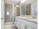 Bathroom features a double sink vanity with a glass-enclosed shower with white cabinetry at 11742 Blackbrook Ct, Seffner, FL 33584