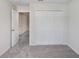 Neutral bedroom featuring plush carpeting, an open doorway, and a closet with bi-fold doors at 11742 Blackbrook Ct, Seffner, FL 33584
