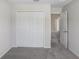Cozy bedroom has neutral carpet, white walls, and a closet with folding doors at 11742 Blackbrook Ct, Seffner, FL 33584