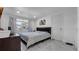 Bright bedroom showcasing a queen-sized bed, marble tile floors, and a window view of the neighborhood at 12416 Queensland Ln, Tampa, FL 33625