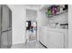 Clean laundry room with a washer and dryer, adjacent to a bright, tiled playroom at 12416 Queensland Ln, Tampa, FL 33625