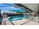 Inviting outdoor pool area with clear blue water, covered seating, and a view of the lake at 12416 Queensland Ln, Tampa, FL 33625