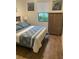 Bright bedroom with wood floors, closet, and a comfortable bed at 12619 Richezza Dr, Venice, FL 34293