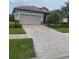 Attractive single-story home with a tile roof, paved driveway, and well-manicured landscaping at 12619 Richezza Dr, Venice, FL 34293