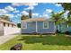 Charming single-story home with a blue exterior, well-manicured lawn, and a decorative front door at 13325 1St E St, Madeira Beach, FL 33708