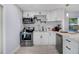 Bright kitchen with white cabinets, stainless steel appliances, and stylish backsplash, perfect for cooking at 13325 1St E St, Madeira Beach, FL 33708