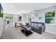Stylish living room with a comfortable sofa, bright windows, and seamless flow to the kitchen area at 13325 1St E St, Madeira Beach, FL 33708