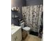Cozy bathroom with floral shower curtain and built-in shelving for storage at 13709 Juniper Blossom Dr, Tampa, FL 33618