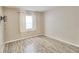 Comfortable bedroom with wood-look flooring, a window, and neutral paint, providing a serene space at 13755 Orange Sunset Dr # 101, Tampa, FL 33618