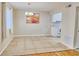 Bright dining area featuring tiled floors and a decorative light fixture, with views into the kitchen at 13755 Orange Sunset Dr # 101, Tampa, FL 33618