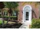 Inviting brick home with a front door framed by lush tropical landscaping and a charming arched entryway at 13755 Orange Sunset Dr # 101, Tampa, FL 33618