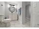 A modern bathroom featuring a sleek vanity, a round mirror, and marble tile floors at 13800 Judy Ave, Hudson, FL 34667