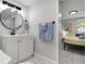 A stylish bathroom with a modern vanity, round mirror, and access to the bedroom at 13800 Judy Ave, Hudson, FL 34667