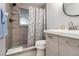 Updated bathroom featuring a shower with decorative curtain, modern vanity, and stylish fixtures at 13800 Judy Ave, Hudson, FL 34667