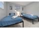 Bright bedroom featuring two twin beds with blue linens and beach-themed wall art at 13800 Judy Ave, Hudson, FL 34667
