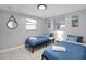 Bright bedroom with blue bedding, side table, and ample natural light at 13800 Judy Ave, Hudson, FL 34667