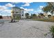 Multi-story home featuring a gravel yard, palm trees, and a well-maintained front lawn at 13800 Judy Ave, Hudson, FL 34667