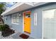 Charming single-story home with a vibrant orange front door and a 'welcome' sign at 13800 Judy Ave, Hudson, FL 34667