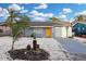 Charming single-story home with a vibrant orange front door and a well-maintained, light gray exterior at 13800 Judy Ave, Hudson, FL 34667