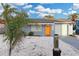 Charming single-story home with a vibrant orange front door and a well-maintained, light gray exterior at 13800 Judy Ave, Hudson, FL 34667