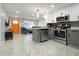 Modern kitchen with stainless steel appliances, gray and white cabinets, and a view into the living area at 13800 Judy Ave, Hudson, FL 34667