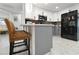 Stylish kitchen features black appliances, gray lower cabinets, white upper cabinets, and barstool seating at 13800 Judy Ave, Hudson, FL 34667