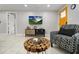 Modern living area with a mounted TV, decorative wood table, and a comfortable patterned armchair at 13800 Judy Ave, Hudson, FL 34667