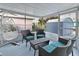 Relaxing screened porch featuring wicker furniture and a hanging swing chair at 13800 Judy Ave, Hudson, FL 34667