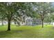 The property boasts a spacious backyard with mature trees, privacy fence, and a screened-in pool area at 14266 Creek Run Dr, Riverview, FL 33579