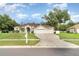 Charming single-story home featuring a well-manicured lawn, a driveway, and a light beige exterior at 14266 Creek Run Dr, Riverview, FL 33579