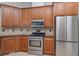Kitchen boasts stainless steel appliances, wooden cabinets and tile backsplash at 14266 Creek Run Dr, Riverview, FL 33579