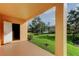 Covered patio providing backyard views of a well-maintained lawn and partial views of nearby homes at 1531 Ember Ln, Tarpon Springs, FL 34689