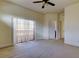 Spacious bedroom with ceiling fan, sliding glass door to balcony, and neutral carpet at 1531 Ember Ln, Tarpon Springs, FL 34689