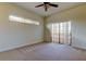 Bedroom with sliding glass door to balcony, ceiling fan, and neutral carpet at 1531 Ember Ln, Tarpon Springs, FL 34689