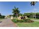 Sunset Bay Townhomes entrance sign with palm trees at 1531 Ember Ln, Tarpon Springs, FL 34689
