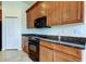 Close up of kitchen featuring custom cabinets, granite counters, tile floor and black appliances at 1531 Ember Ln, Tarpon Springs, FL 34689