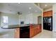 Kitchen featuring custom cabinets, granite counters, tile floor and black appliances at 1531 Ember Ln, Tarpon Springs, FL 34689