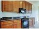 Close up of kitchen featuring custom cabinets, granite counters and black appliances at 1531 Ember Ln, Tarpon Springs, FL 34689