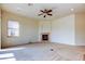 Bright living room featuring neutral walls, a fireplace, ceiling fan, and a large window at 1531 Ember Ln, Tarpon Springs, FL 34689