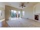 Bright living room with fireplace and sliding glass doors to the balcony overlooking the trees at 1531 Ember Ln, Tarpon Springs, FL 34689