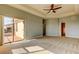Sunlit carpeted main bedroom with balcony access, a ceiling fan and ensuite bathroom at 1531 Ember Ln, Tarpon Springs, FL 34689