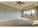 Bright, spacious carpeted main bedroom with a ceiling fan and a large window at 1531 Ember Ln, Tarpon Springs, FL 34689