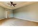 Spacious carpeted main bedroom with a ceiling fan, a tray ceiling and ensuite bathroom at 1531 Ember Ln, Tarpon Springs, FL 34689